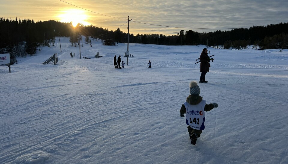 solnedgang over skistadion med barn