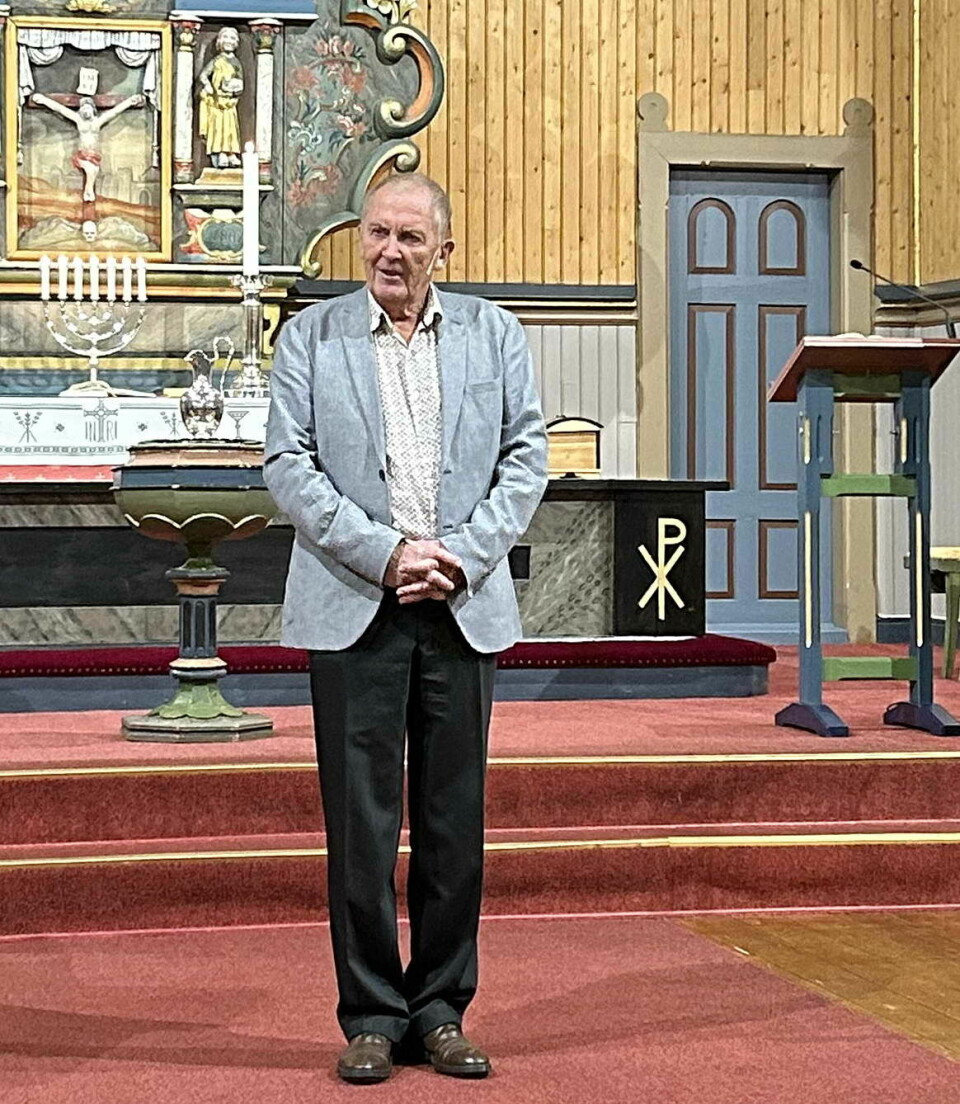 En mann som står i koret i ei kirke.