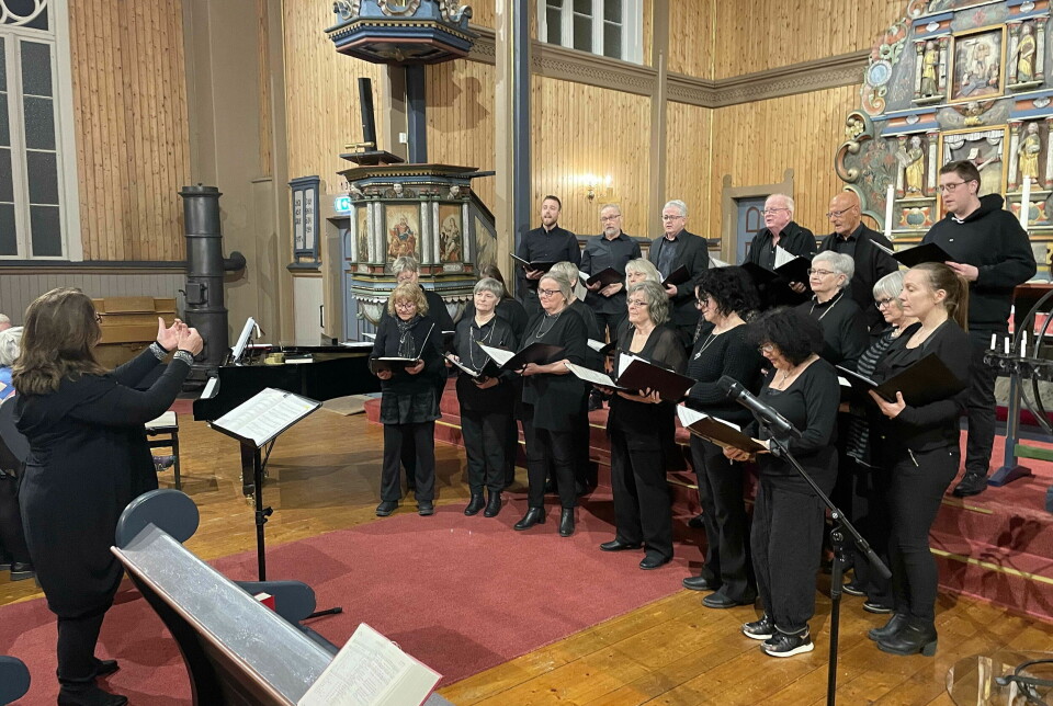Et sangkor med dirigent i ei kirke.
