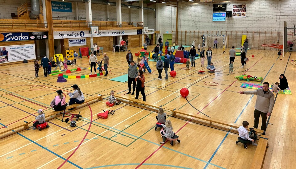 Mange barn som leker med ulike aktiviteter i en idrettshall