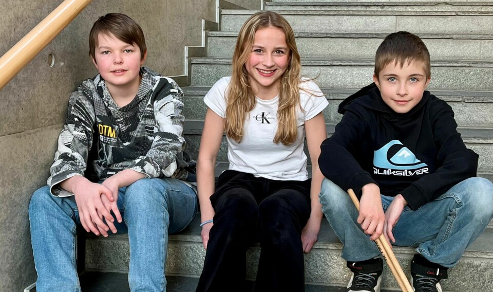Tre ungdommer som sitter i ei trapp.