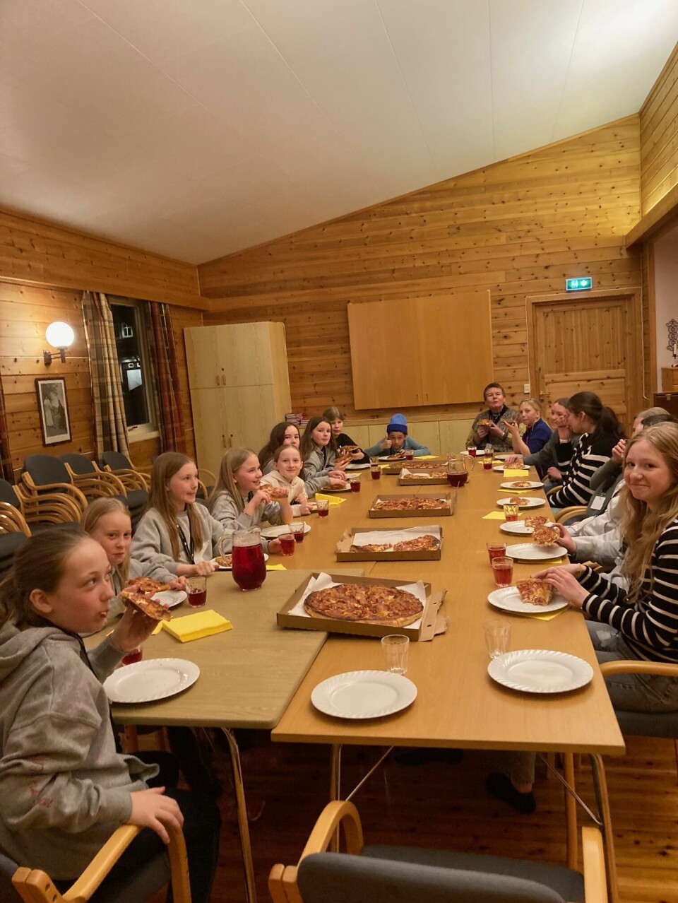 Barn spiser pizza rundt bordet