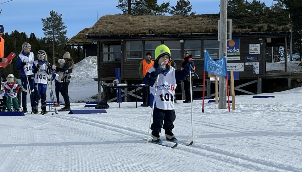 Liten gutt på ski. Flere skiløpere i bakgrunnen