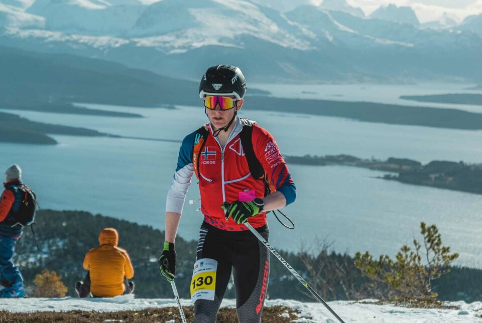 Aron Rodal Haugen En ung mann som går i en skikonkurranse. Fjord og fjell i bakgrunnen.