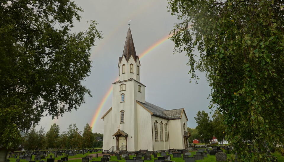 Rindal kirke Ei kirke, med en regnbue bak.