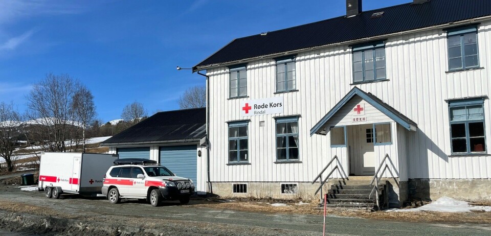Røde Kors-huset i Rindal, med en bil og en snøscooterhenger utenfor.