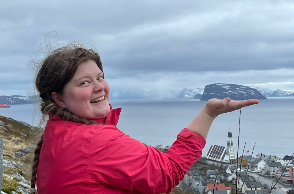 Her er Ida på Salen med utsikt over Hammerfest by hvor hun har øya Håja 'i hånden'. Dame med fletter holder en hånd slik at det ser ut som hun holder en øy i hånden.