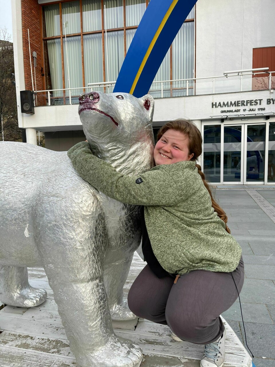 En dame holder rundt en skulptur av en bjørn