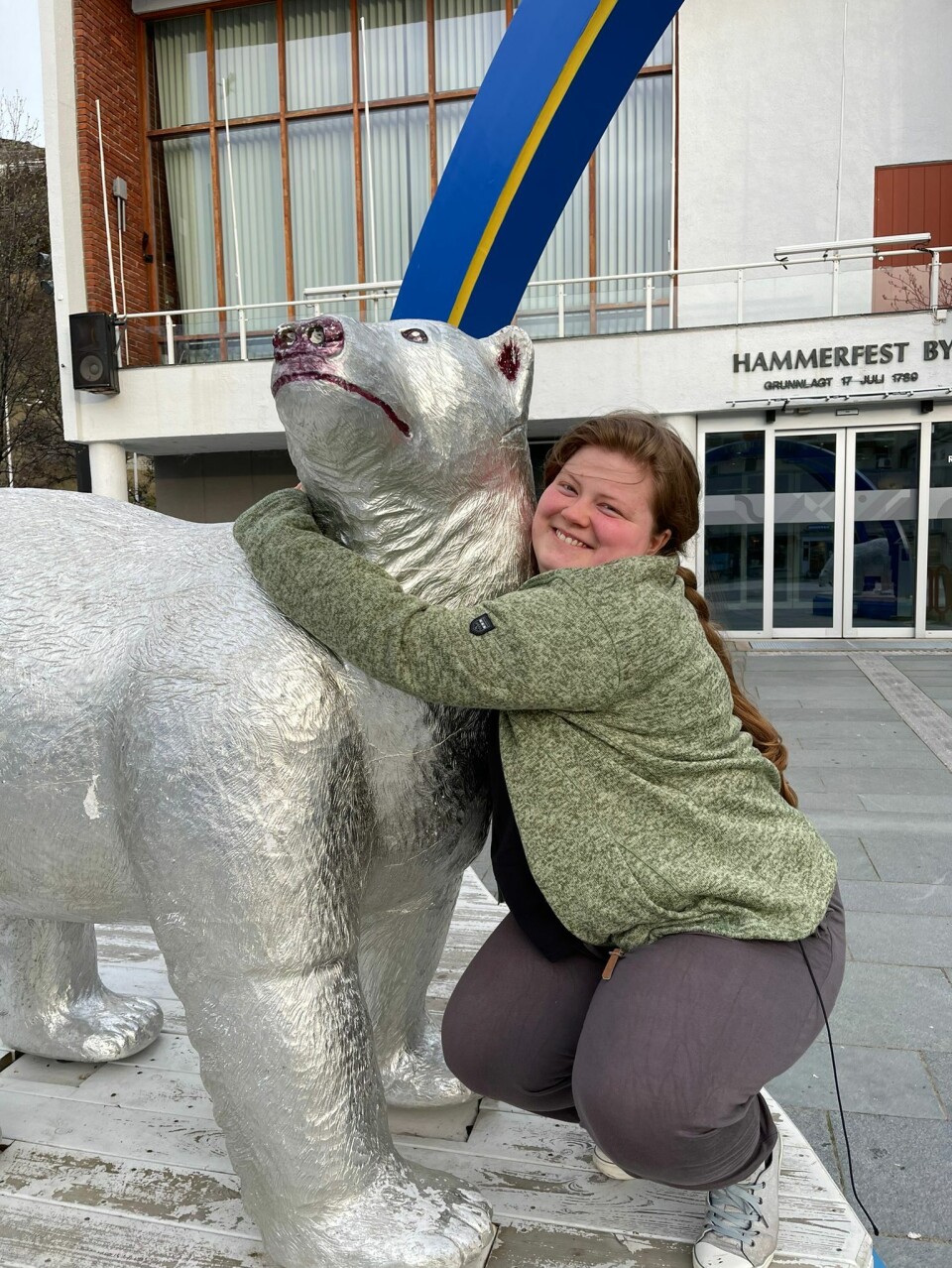 Ida foran kommunehuset i Hammerfest. En dame holder rundt en skulptur av en bjørn