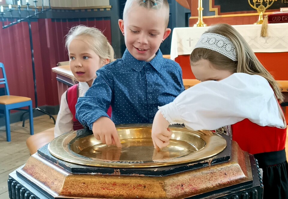 Barn kjenner på dåpsvatnet etter gudstenesta
