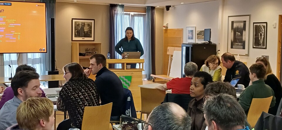 En engasjert Maren Mildestvedt leder an. En kvinne leder møtet mens andre voksne snakkker