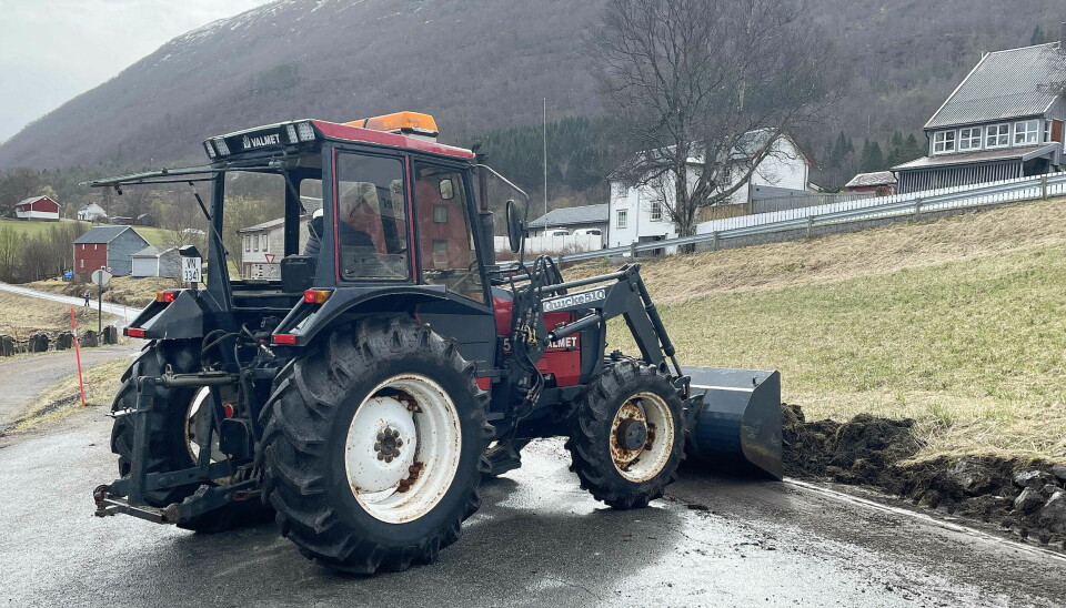 En traktor graver langs veien