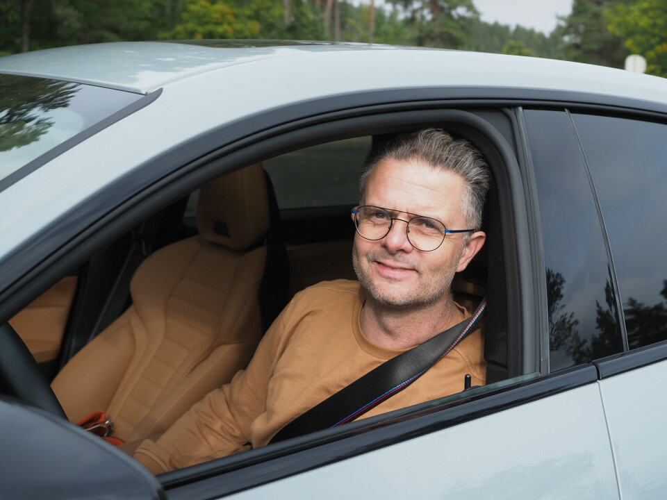 En mann som sitter i førersetet på en bil og ser ut det åpne sidevinduet.