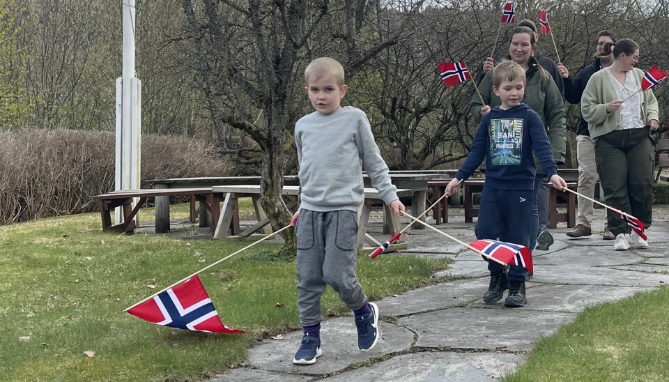 to gutter med norsk flagg. Det kommer 3 voksne bak også med flagg.