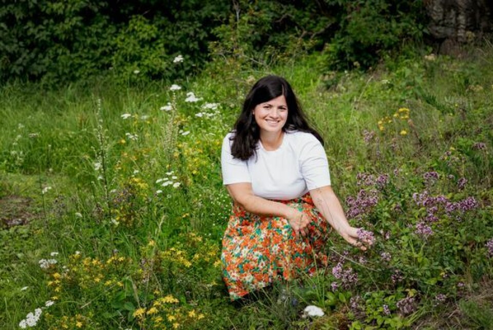 Når du lar plenen stå, er du med på å gjøre jorda litt villere. På bildet: Generalsekretær i WWF Verdens naturfond Karoline Andaur. En kvinne sitter i en hage med mange villblomster
