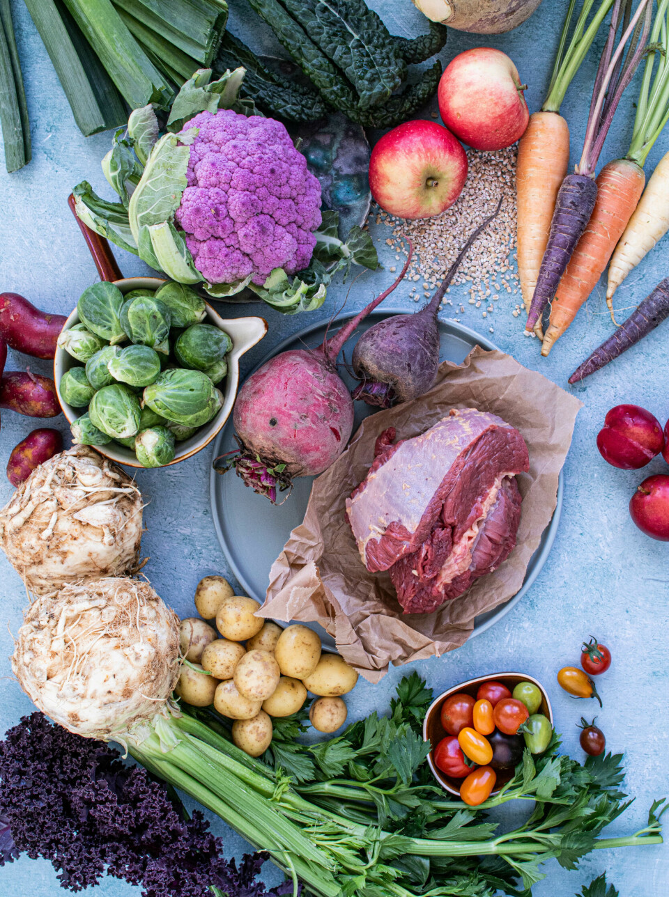 Kjøtt, frukt og grønnsaker på et bord.