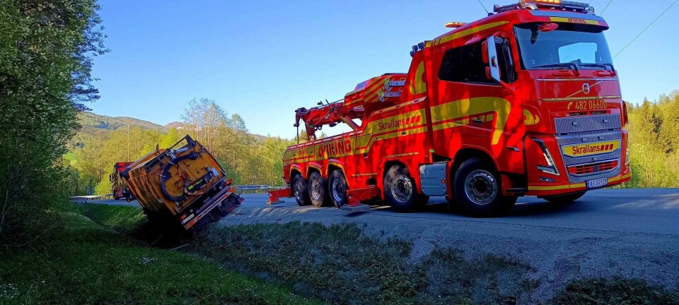 Bilberging i Mjohølkrysset i Rindal onsdag kveld - Veien er åpnet igjen! To tungbilbergere som gjør seg klar til å dra opp en lastebil som har kjørt utfor veien.