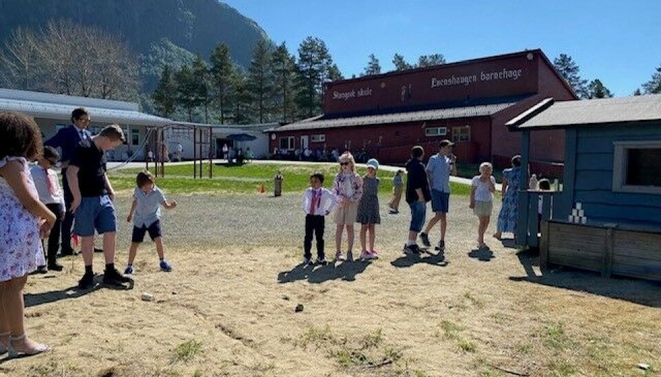 Kasting på blikkboks. barn er pyntet i skolegård