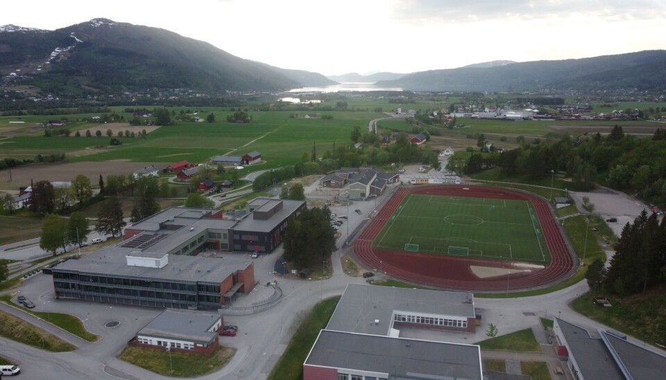 En sen mai-kveld med utsikt over Øye og Sylte. dronefoto av skole og idrettsbane
