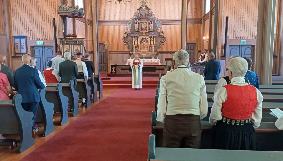 Høytidsgudstjeneste Stangvik kirke. menighet står i kirke med prest foran