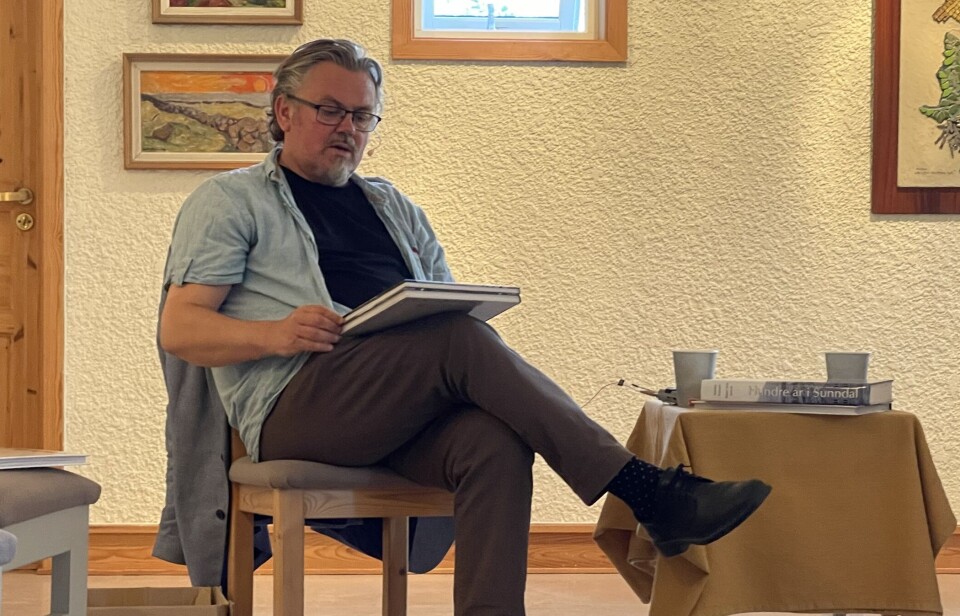 Mange bilder i bøkene som er historisk interessante En mann sitter på en stol med en bok i fanget