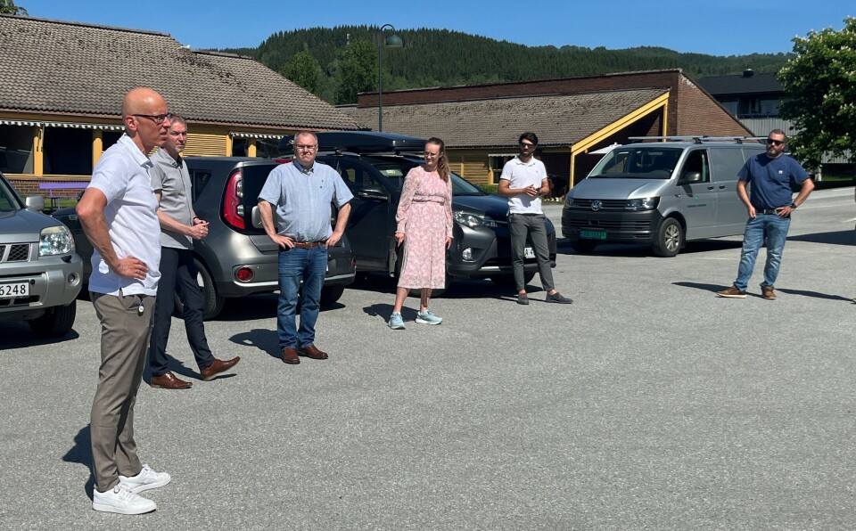 Kommunestyret på befaring på sjukeheimsområdet. Seks personer på en parkeringsplass.