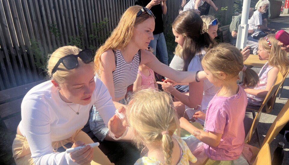 Barna kunne få ansiktsmaling før showet på kulturhustorget. ungdomsjenter maler ansiktet til barn ute