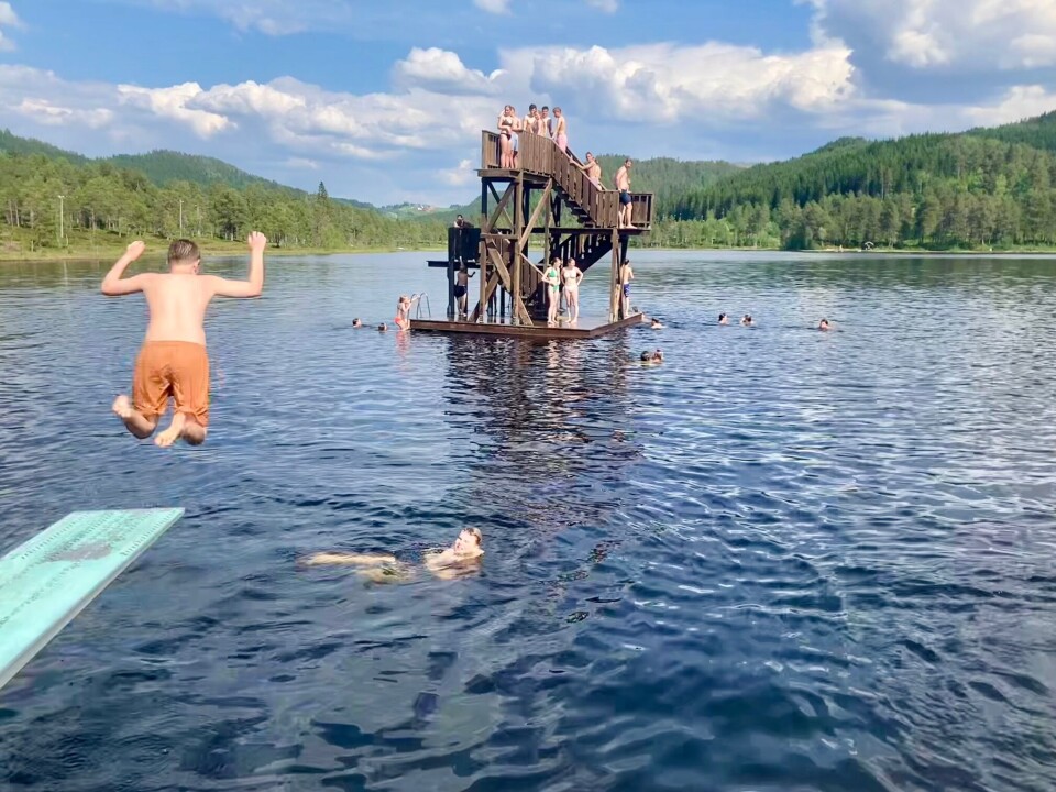 Håvard i farta! Sivert Magnus som ligger i vannet sier om temperaturen: 'Drittkaldt noen plasser, heitt andre plasser'. Gutt som hopper fra stupebrett ut i vannet. Mange på stupetårnet i bakgrunnen.
