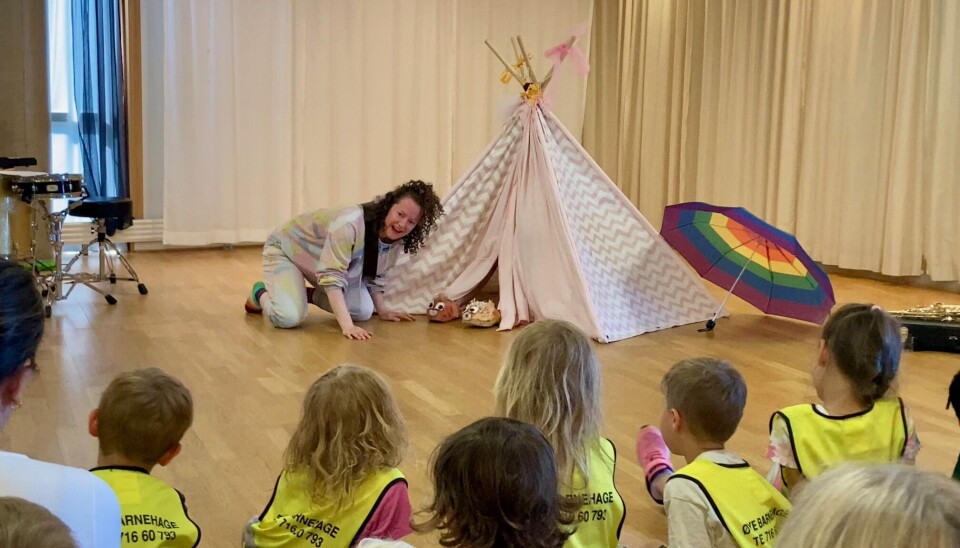 Alle ler når Mio og Pio foreslår å lage en 'Prompafon' Skuespilleren ler og snakker med to figurer i en tipi.
