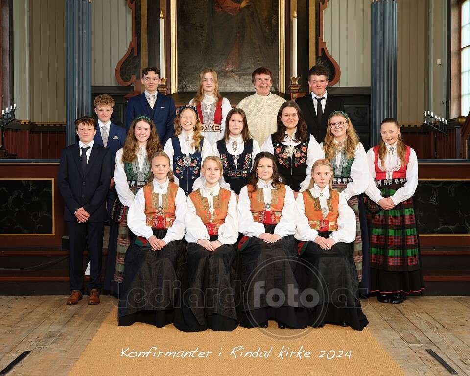 Konfirmantene, og prest Lene Gåsvatn. 16 konfirmanter og en prest oppstilt til fotografering i koret i kirka.