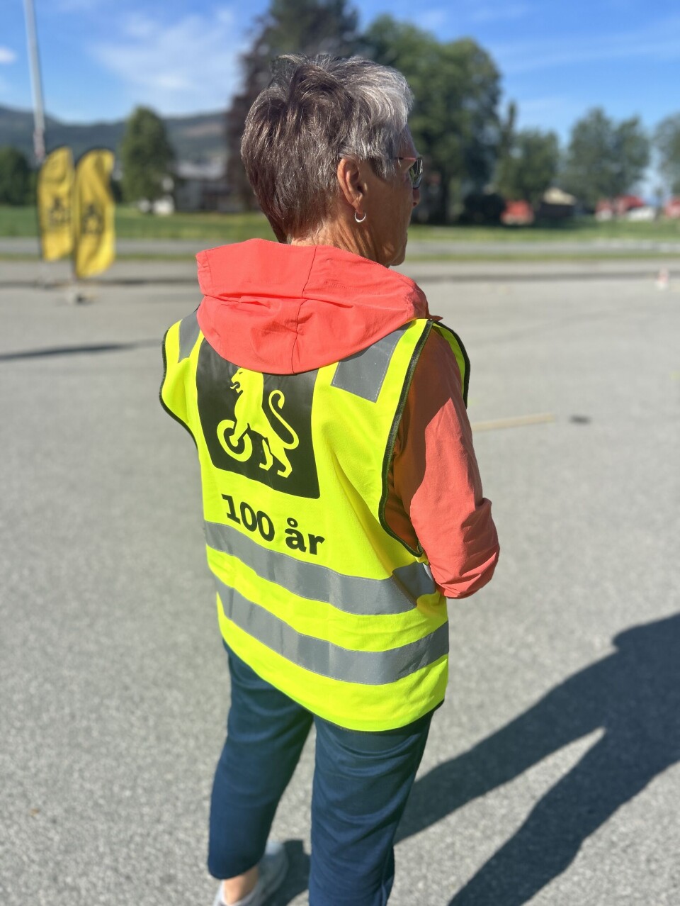 NAF feirer 100 år. Dame med refleksvest med påskriften '100 år' og NAFs logo som er en løve med hjul på frambeina