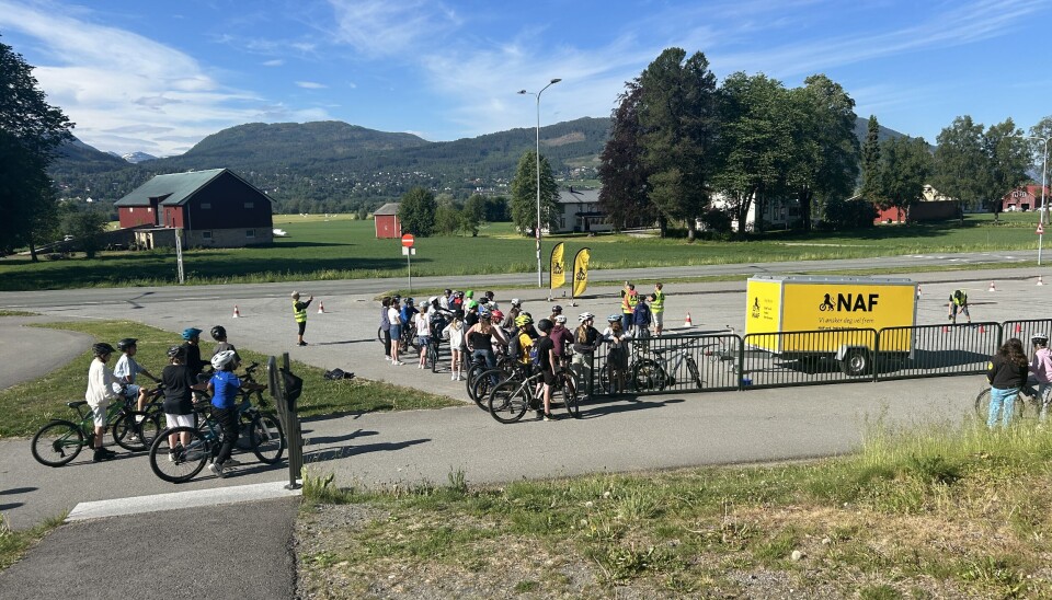 NAF er arrangører for sykkeldagen. Barn på sykler med hjelm, og en henger med NAFs logo