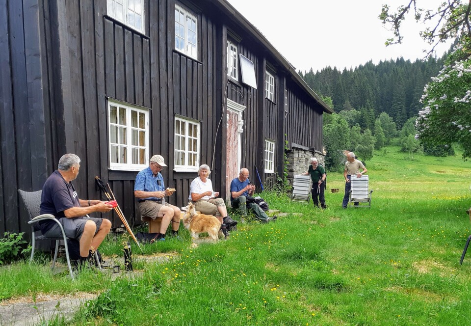 Ved garden Mennesker foran en husvegg.