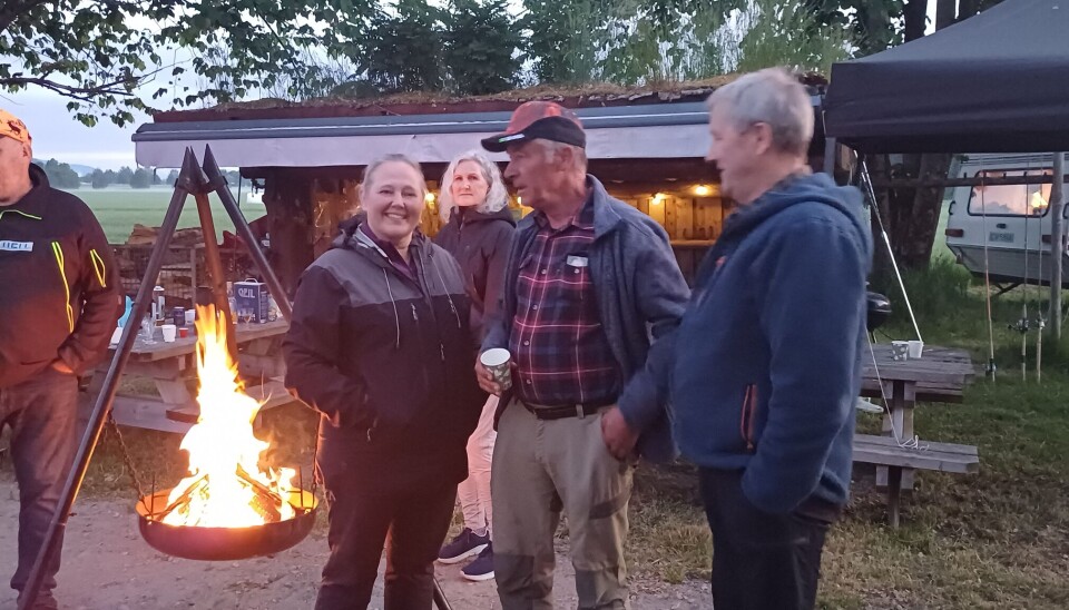 Anett Ranes og Georg Solem med fiskere ved gapahuken på Austistua-Øye. folk rundt bålpanne