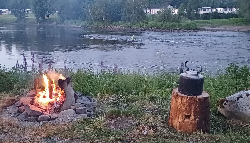 Laksefisker med kaffelars og kubbebål Austistua-Øye. bål ved elv