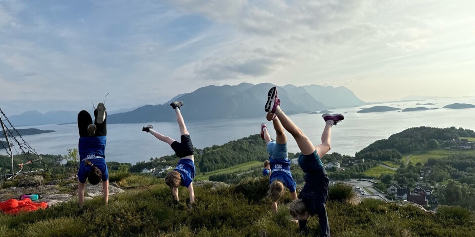 En flott tur til Gossen for Surnadal idrettslag turn. Barn som står på hender på en høyde med nydelig utsikt til fjell og sjø