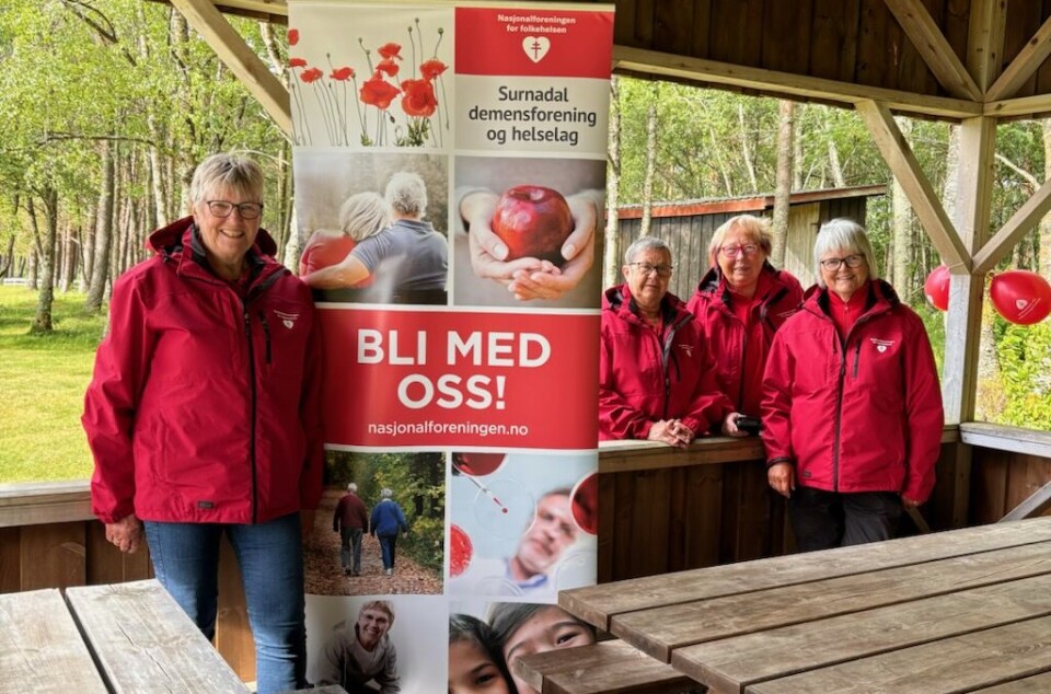 Damene i styret er klare for årets Hjertemarsj. Blide damer med banner for Surnadal demensforening og hjertelag