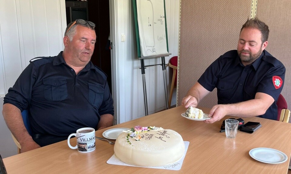 Det ble nok kake, både til feierne og kollegene i teknisk avdeling. To menn i brannvesen-skjorter, som sitter ved et bord og forsyner seg med kake.
