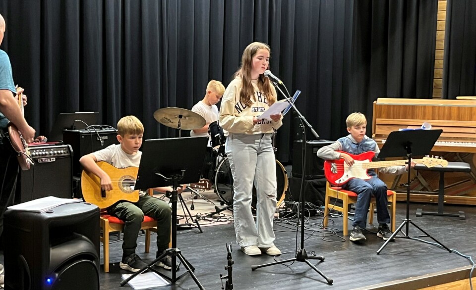 Olai, Peder, Ida og Kasper. Ei jente som synger og tre gutter som spiller bandinstrumenter på scenen.