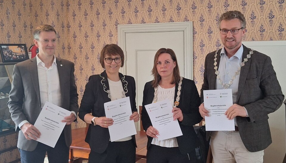 Kommunal- og distriktsminister Erling Sande, ordfører i Rindal Mildrid Kattem Aune, varaordfører i Holtålen Liv Grete Heksem og fylkesordfører i Trøndelag Tomas Iver Hallem med hvert sitt eksemplar av den signerte Bygdevekst-avtalen. Fire personer som står ved siden av hverandre med hvert sitt dokument i hendene.