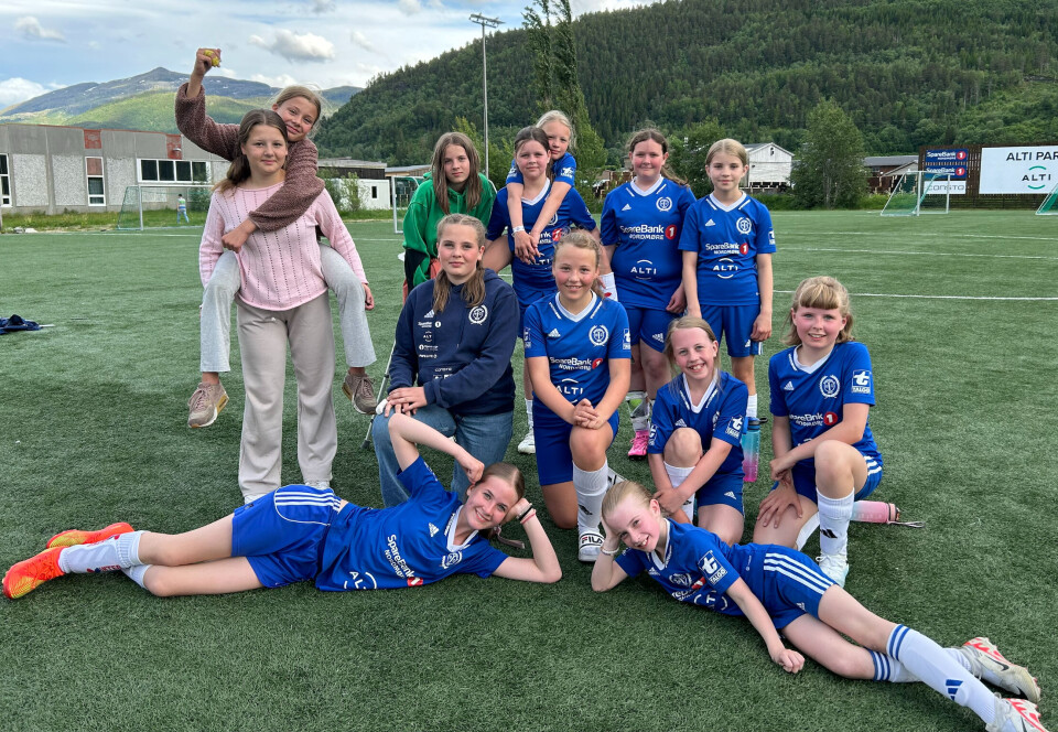 Surnadal IL J12. Et jentefotballlag (12-årslag) oppstilt for fotografering på en fotballbane.