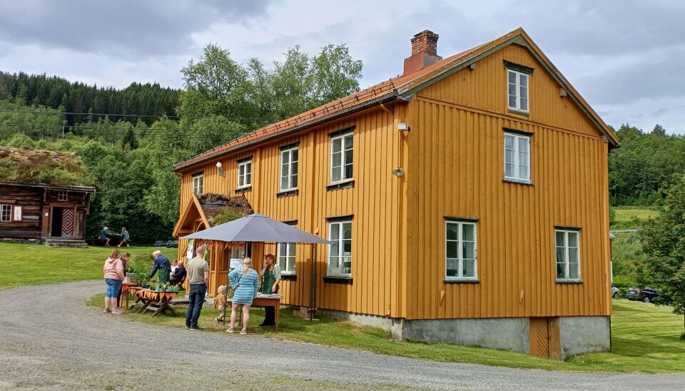 Planteloppemarkedet i gang. gult stort hus med folk utenfor