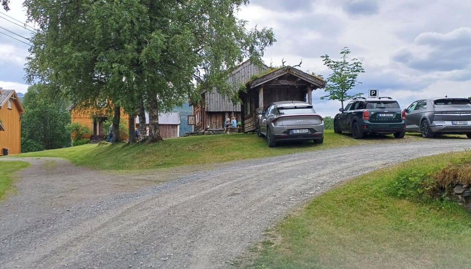 Folk koste seg i finværet. biler parkert ved grusveg