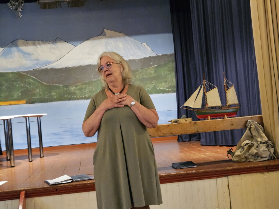 Turid Røen Kroknes song Lascia ch´io pianga. Dame som synger foran scene med bilde av fjell og fjord. En båt og en gammel ryggsekk er utstilt bak.
