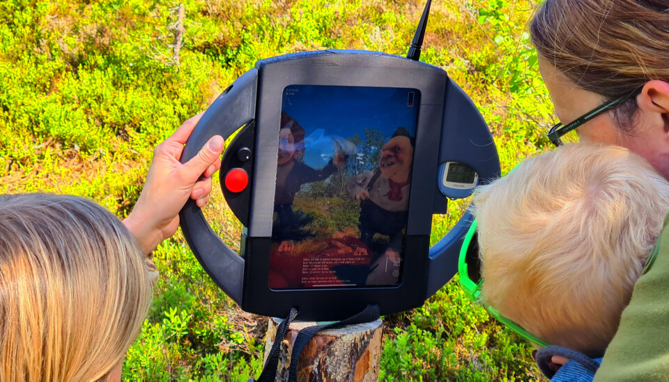 Boll og Bøllu - to helt forskjellige tvillingtroll som du vil kunne få møte i 'Home of the Trolls' To voksne og ett barn ser på en 'pad' der to troll snakker til dem