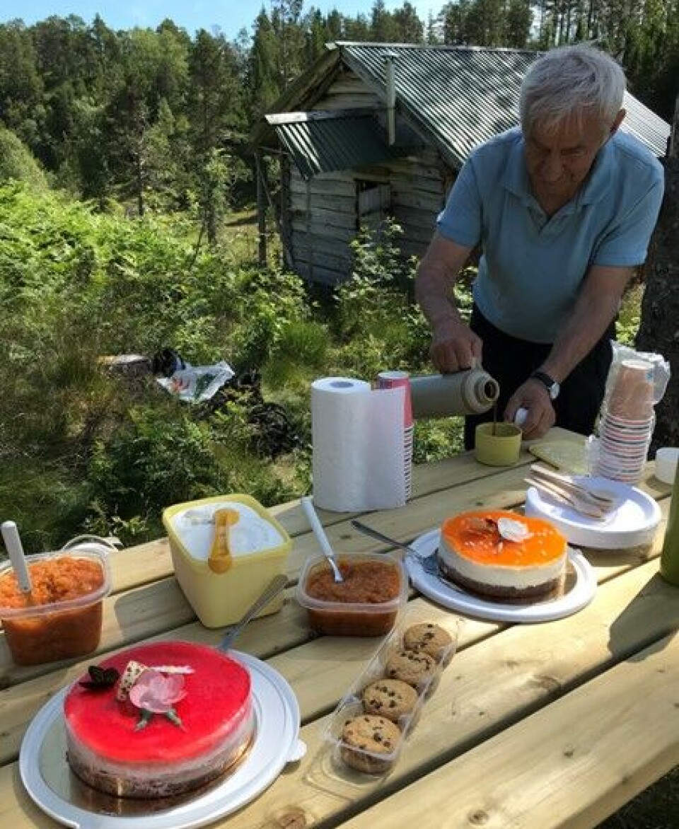 Servering. En mann som sjenker opp kaffe fra et bord med flere gode kaker.