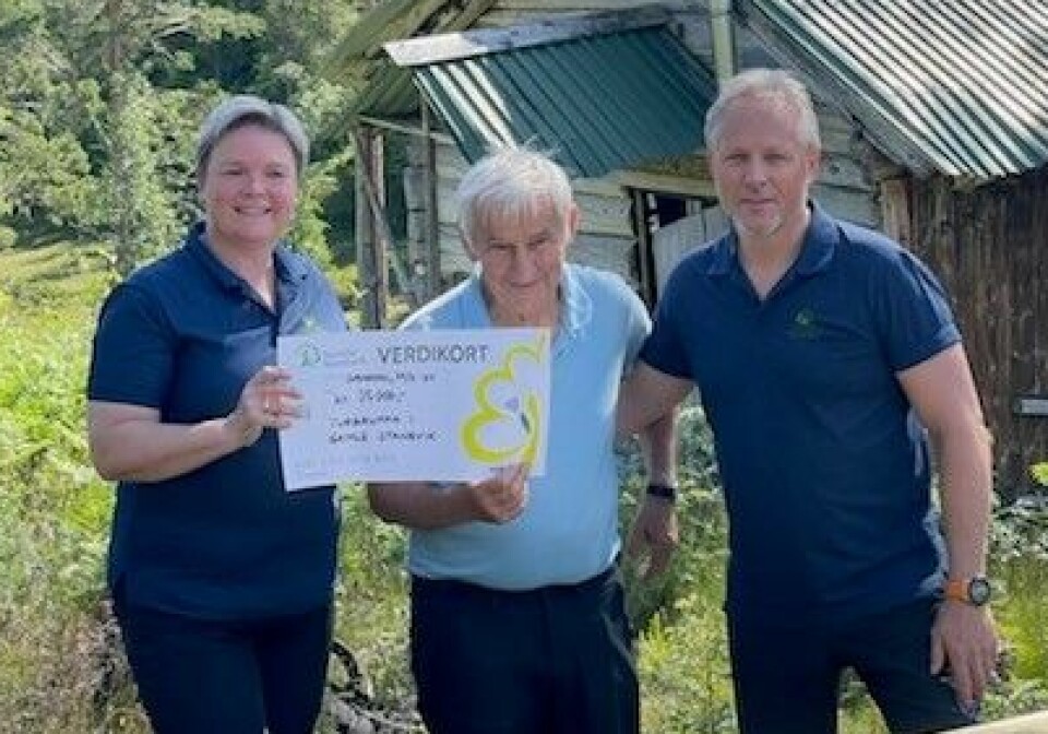 Svein Aarnes fra turstigruppa flankert av Mette Helen Mikkelsen og Steinar Aasbø fra Sunndal Sparebank. To menn og ei dame som holder en gavesjekk foran seg.