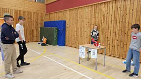 Bod med ballkast. fire gutter ser at en 5. gutt har truffet boksene med ball.