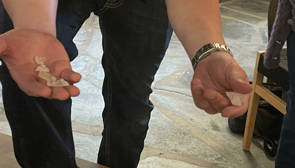 Det var ikke bare flint å finne i kassen til Torvik, her er det blant annet bergkrystaller To hender viser frem hvite bergkrysstaller. I høyre hånd har han en, i venstre hånd 5 stener