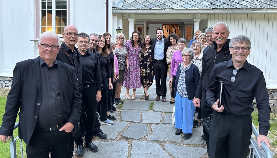 Dei fleste aktørane klar til konsert. Mange mennesker oppstilt til fotografering utenfor ei kirke.